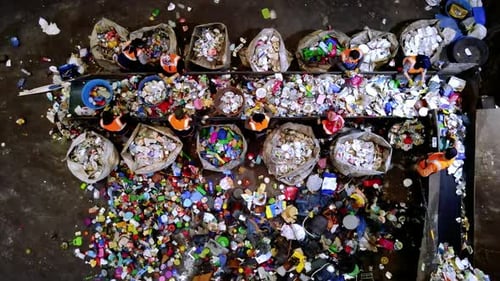 Recycling Center Workers Sort Trash On A Conveyor