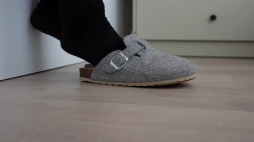Person putting on slippers when getting out of bed. Close up