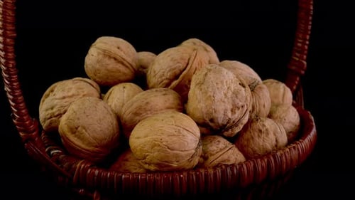 Basket Full of Walnuts Rotating on Black Background
