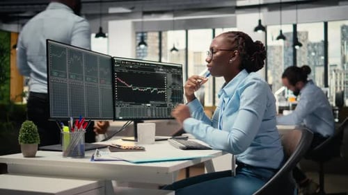 Forex Expert in Office Looking Over Candlestick Charts on Screen