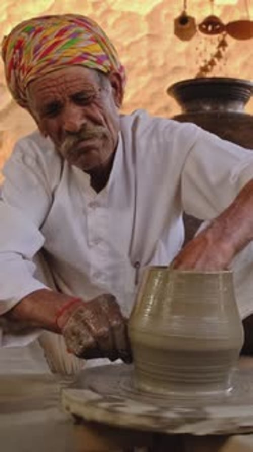 Potier indien au travail, lançant le tour de potier et façonnant des objets en argile, Rajasthan, Inde