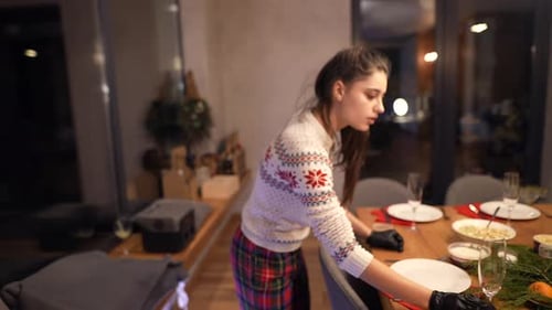 Beautiful Girl Preparing Decorations on the Wooden Table with Meals for Christmas Party