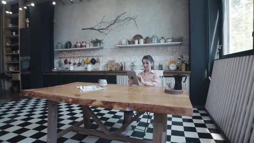 Woman Using Tablet at Table Indoors