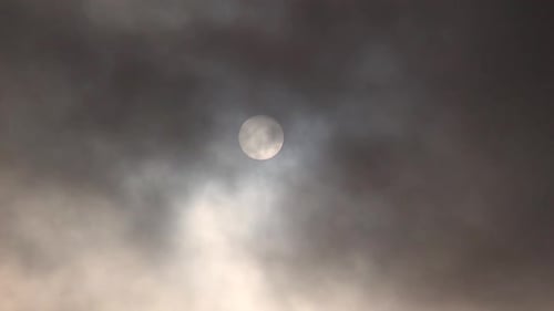 Sonne hinter dunklen Wolken gezoomtes Filmmaterial