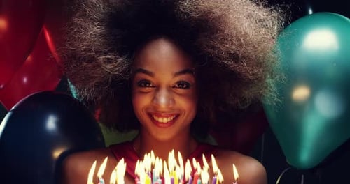 Smiling Woman Holding Birthday Cake with Candles