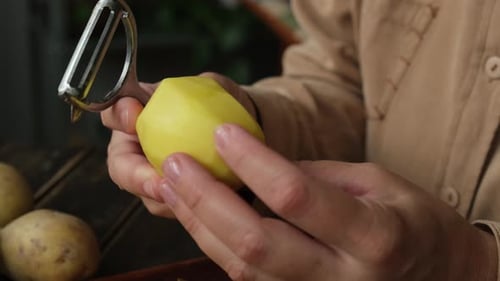 Woman Peeling Raw Potato