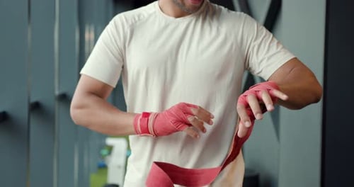 Athlete Wrapping Hands in Boxing Wraps at Gym