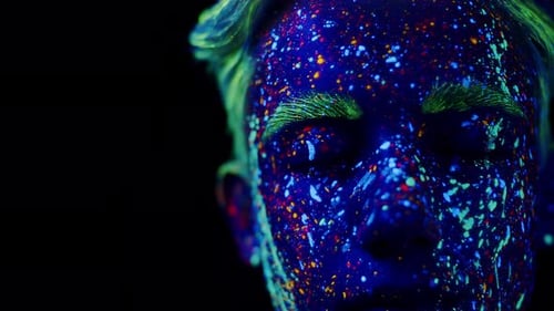 Portrait of Young Male Performer Which Open His Eyes Close Up with Fluorescent Multicolor Drips on