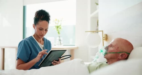 Attentive Nurse Using Tablet with Senior Patient