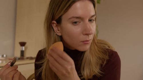 Woman Applies Foundation With Brush and Sponge