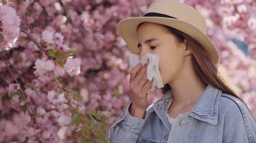 Woman with Allergies by Blossoming Spring Tree