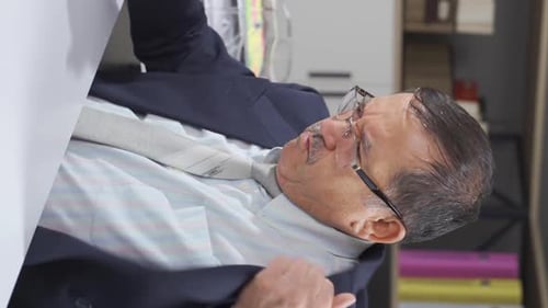 Man in Suit Adjusting Tie at Desk