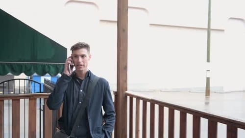 Man walking and talking on cell phone outdoors