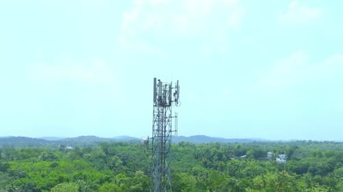 Telecommunication tower with 5G cellular network antenna on green trees background