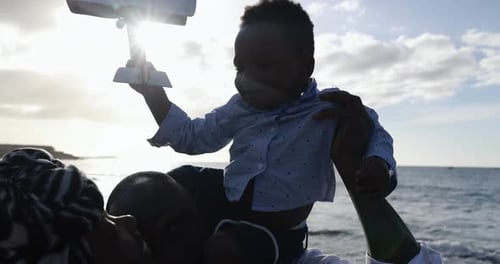Baby Plays with Toy Airplane at the Beach