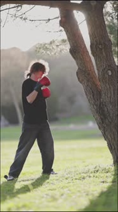 Young Adult Practicing Boxing in a Sunny Park