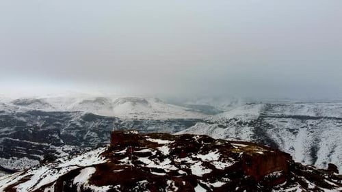 Drone Perspective of a Ruined Armenian Church Perched on a Snowy Cliff Edge in Ani, Turkey