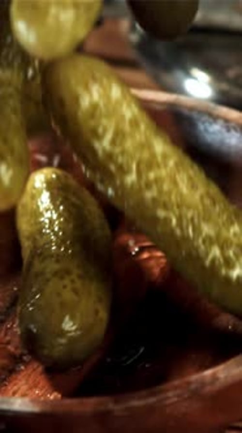 Pickled Cucumbers Fall Into a Wooden Bowl Filmed on a Highspeed Camera at 1000 Fps