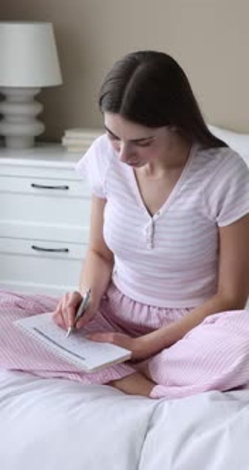 Menstruation. Woman with period calendar application on her phone suffering from pain on bed at home