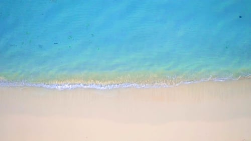 Waves crashing on tropical island beach paradise aerial drone view