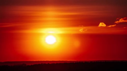 Timelapse of Dramatic Sunset in the Orange Sky Over the Horizon