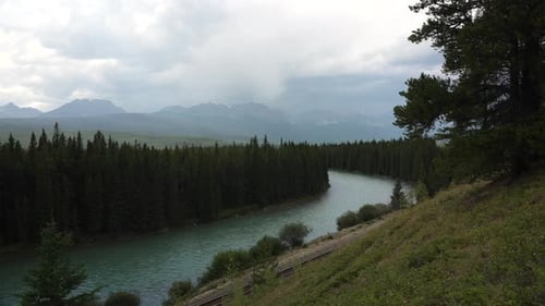 timelapse of clouds rolling over mountain peaks the bow river flowing in Banff. Ab