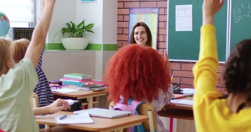 Rear on Kids in School Rising Hands While Answering to Eacher in Classroom Back View Children in