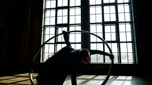 Un acrobate tourbillonnant dans un grand cerceau dans un dancehall, personnage tiré au ralenti d'un film fantastique