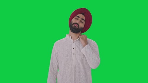 Sick Sikh Indian man suffering from neck pain Green screen
