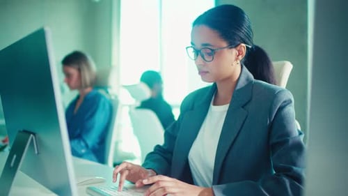 Professional Woman Typing in a Modern Office Setting