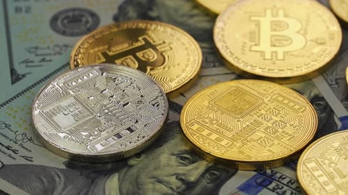 Bitcoin coins on top of US Dollar Bills