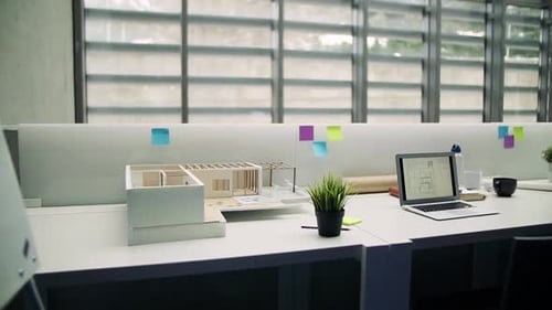 Laptop and Model of a House in Interior of Office of Architects