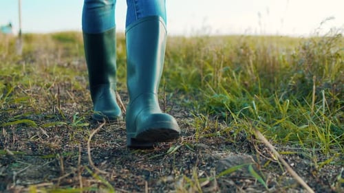 Unrecognizable Farmer Going with Rubber Boots Along Green Field Rubber Boots for Work Use A Worker
