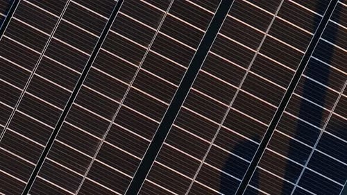 Aerial drone view of solar panels at sunset. Photovoltaics on top of the roof of the building. Alter
