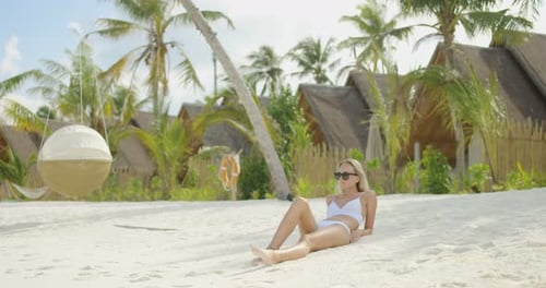 Beautiful Blonde Woman Lying on the Beach. In the Background Azure Sea and White Sand. Paradise on