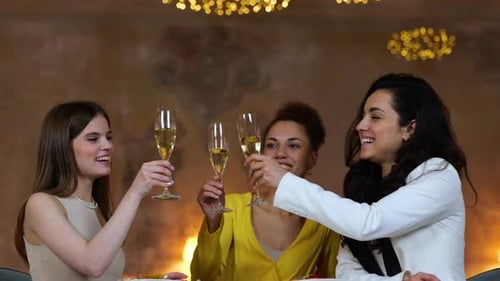 Young Female Friends Toasting and Drinking Champagne While Sitting in the Restaurant and Resting
