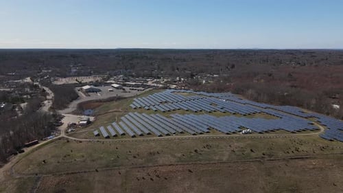 A slow drone approaching shot of an array of solar panel rows. Aerial. Green energy. Solar.