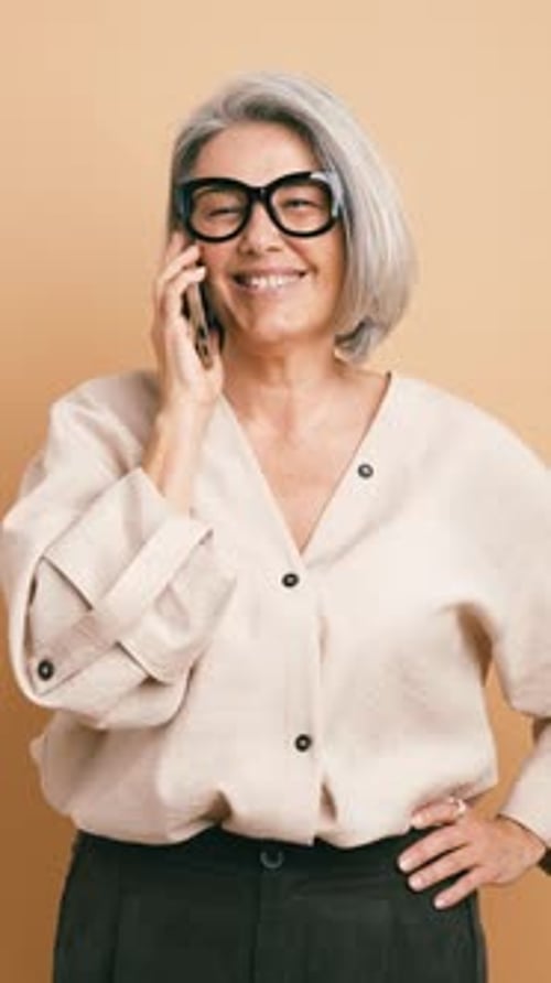 Mature Stylish Businesswoman Talking on a Smartphone Vertical
