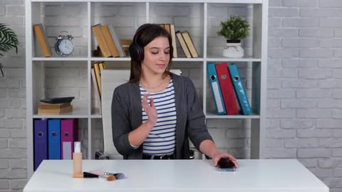 Young Woman Dancing with Headphones in Bright Room