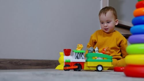 Baby Plays with Toy Train and Stacking Rings