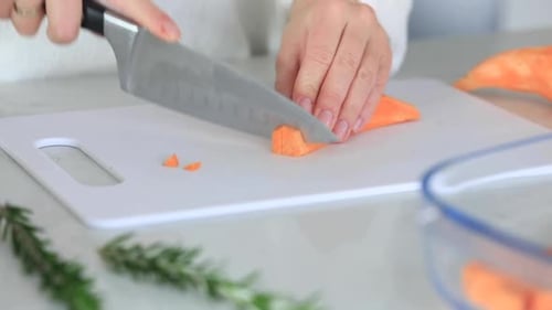 A Woman Cuts Sweet Potatoes on a Cutting Board Video Cooking Sweet Potatoes