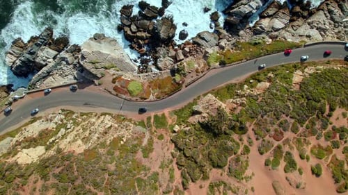 Aerial View of Cars on Scenic Oceanfront Road Along Rocky Coastline