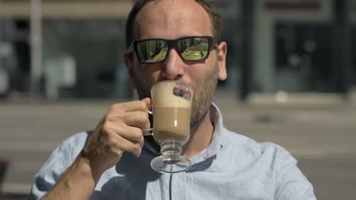 Portrait Of Young, Happy Man Drinking Coffee In Cafe In City
