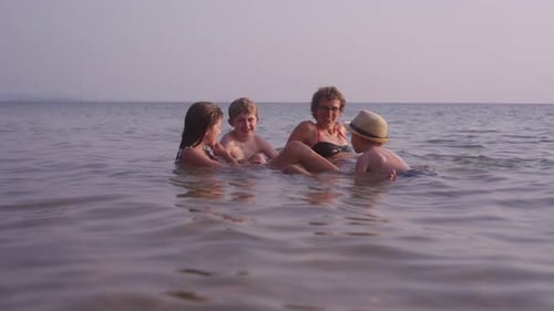 Mom Swimming With Kids On A Tropical Beach