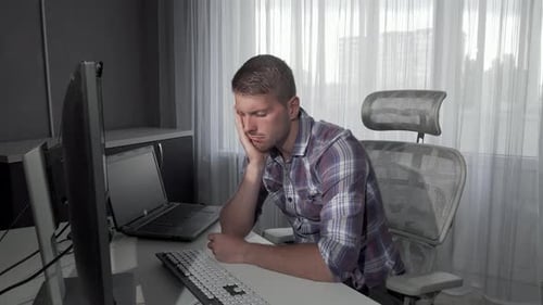 Tired Young Adult Falling Asleep at Desk