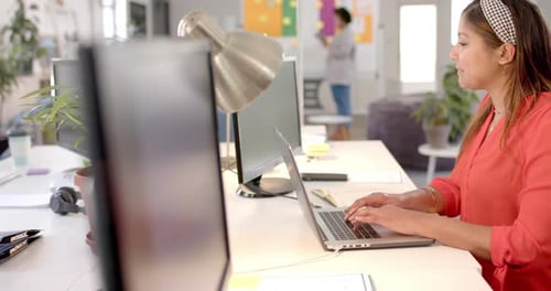 Caucasian casual businesswoman using laptop in office, slow motion