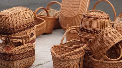 Wicker baskets piled on a table in the street. Lateral motion shot.