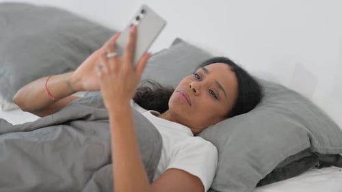Woman Lying in Bed Using Mobile Phone
