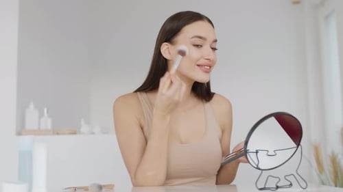 Close Up Portrait of Young Pretty Woman Making Everyday Makeup Applying Rouge on Face Smiling to Her