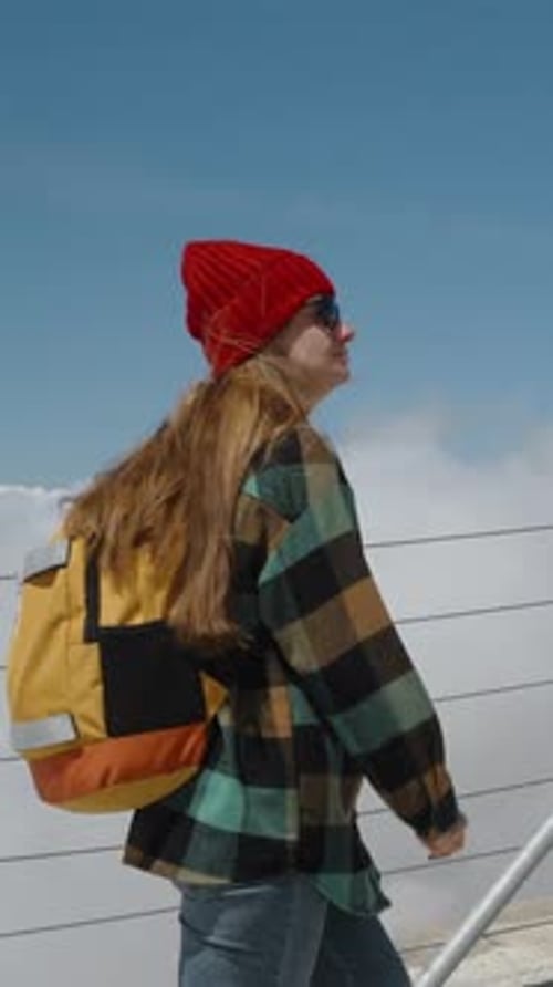 Young Adult Walks Outdoors with Backpack on a Sunny Day